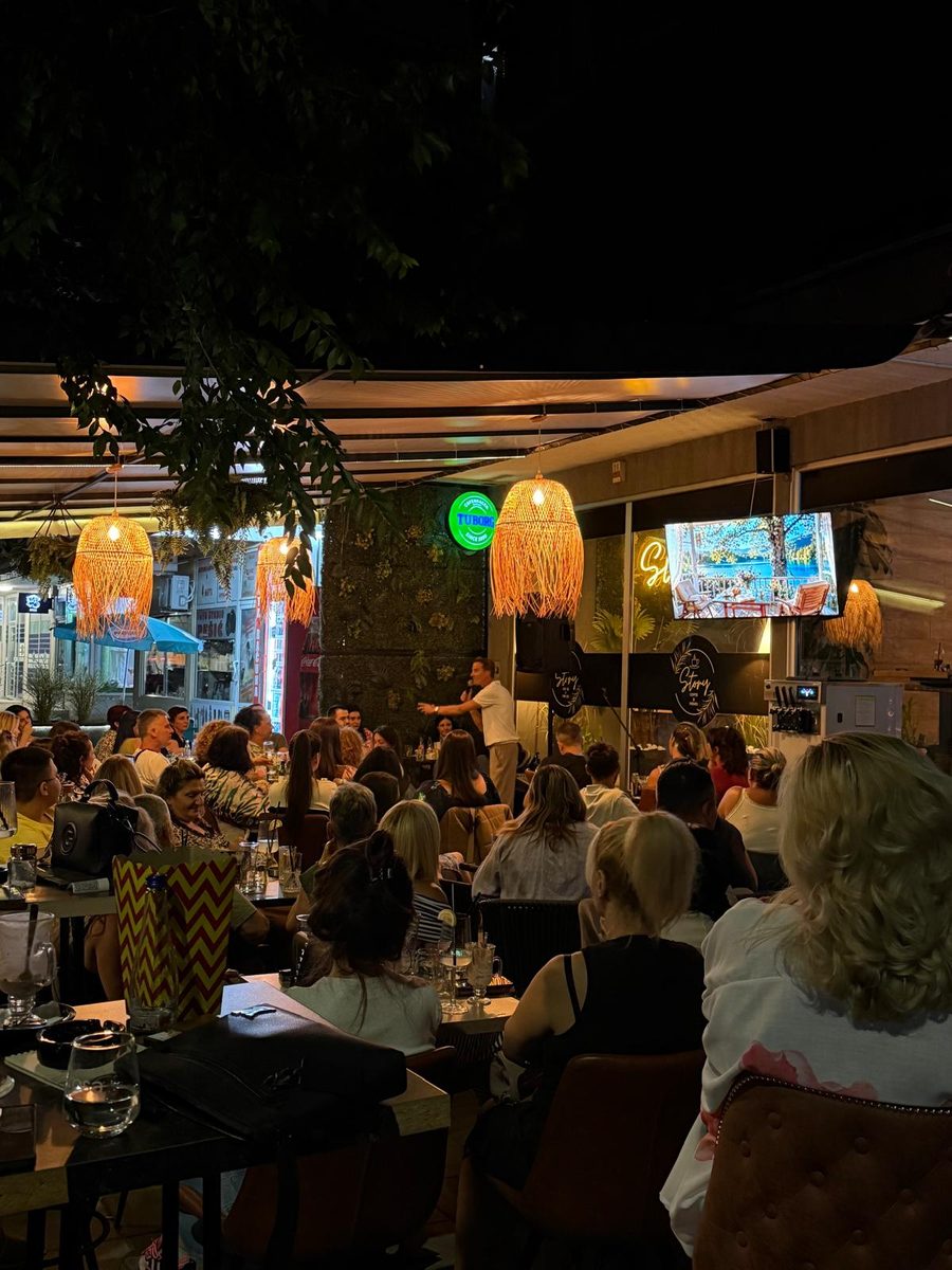 Stand-up komičar na bini ispred publike u Caffe Story